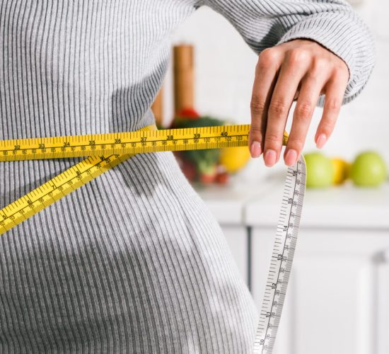 panoramic shot of young woman measuring waist